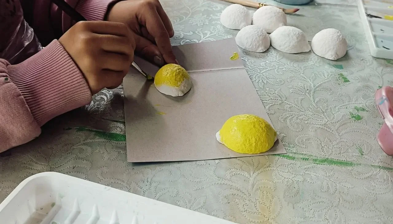 Руки с кистью за росписью заготовок, без лиц участников